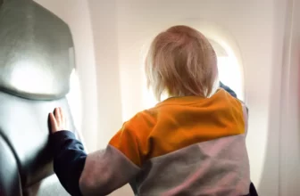 Kleines Kind im Flugzeug guckt aus dem Fenster