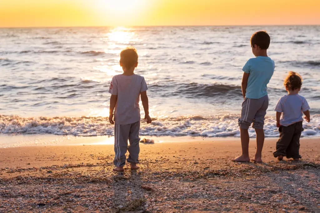 Kinder am Meer bei Sonnenuntergang
