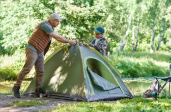 Vater und Sohn stellen ein Zelt auf am Campingplatz