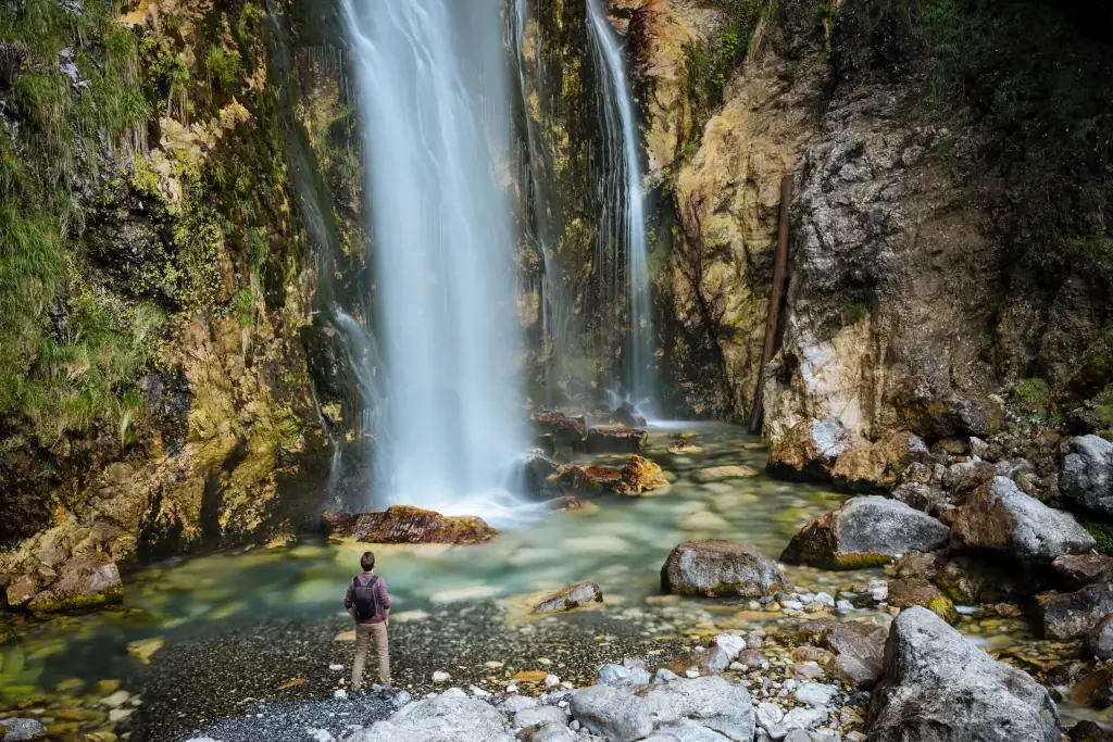 Wanderer mit Blick auf Wasserfall, Verfluchte Berge, Theth, Shkoder, Albanien, Europa