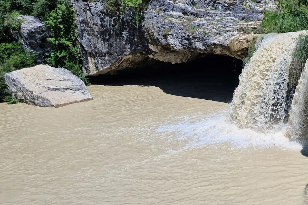 Wasserfall Zarecki krov bei Pazin mit Höhle unter dem Felsdach und braunem Wasser