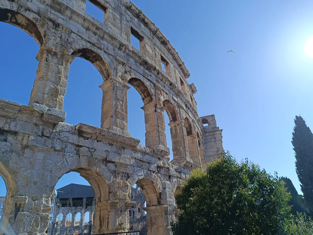 Bögen der Arena von Pula von unten gegen den blauen Himmel
