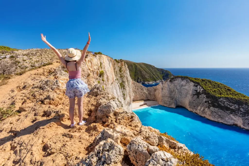 Touristische Frau in Zakynthos, Griechenland, bewundert den Strand von Navagio