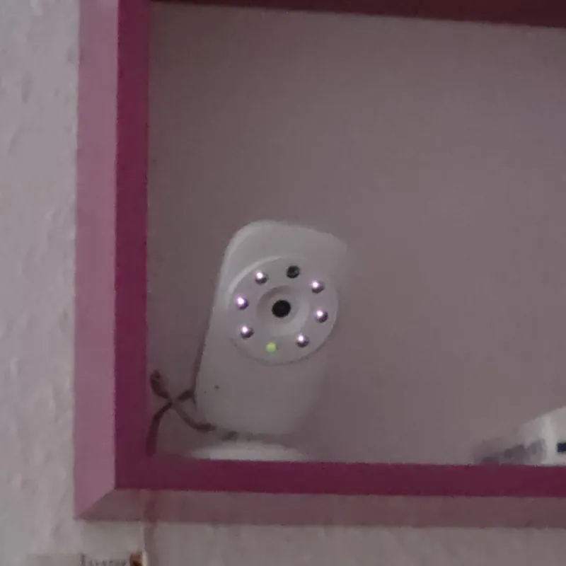 Kamera unseres Babyphones steht in einem Wandregal, mit Abstand zum Bett statt direkt auf dem Nachttisch