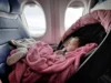 Baby in Autositz schläft in einem Flugzeug