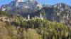Städtereisen mit Kindern in Deutschland: Schloss Neuschwanstein vor den Bergen im Frühling