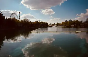 Ein Gewässer mit einem Riesenrad im Hintergrund https://unsplash.com/de/fotos/ein-gewasser-mit-einem-riesenrad-im-hintergrund-nRTBAXJ4ONc